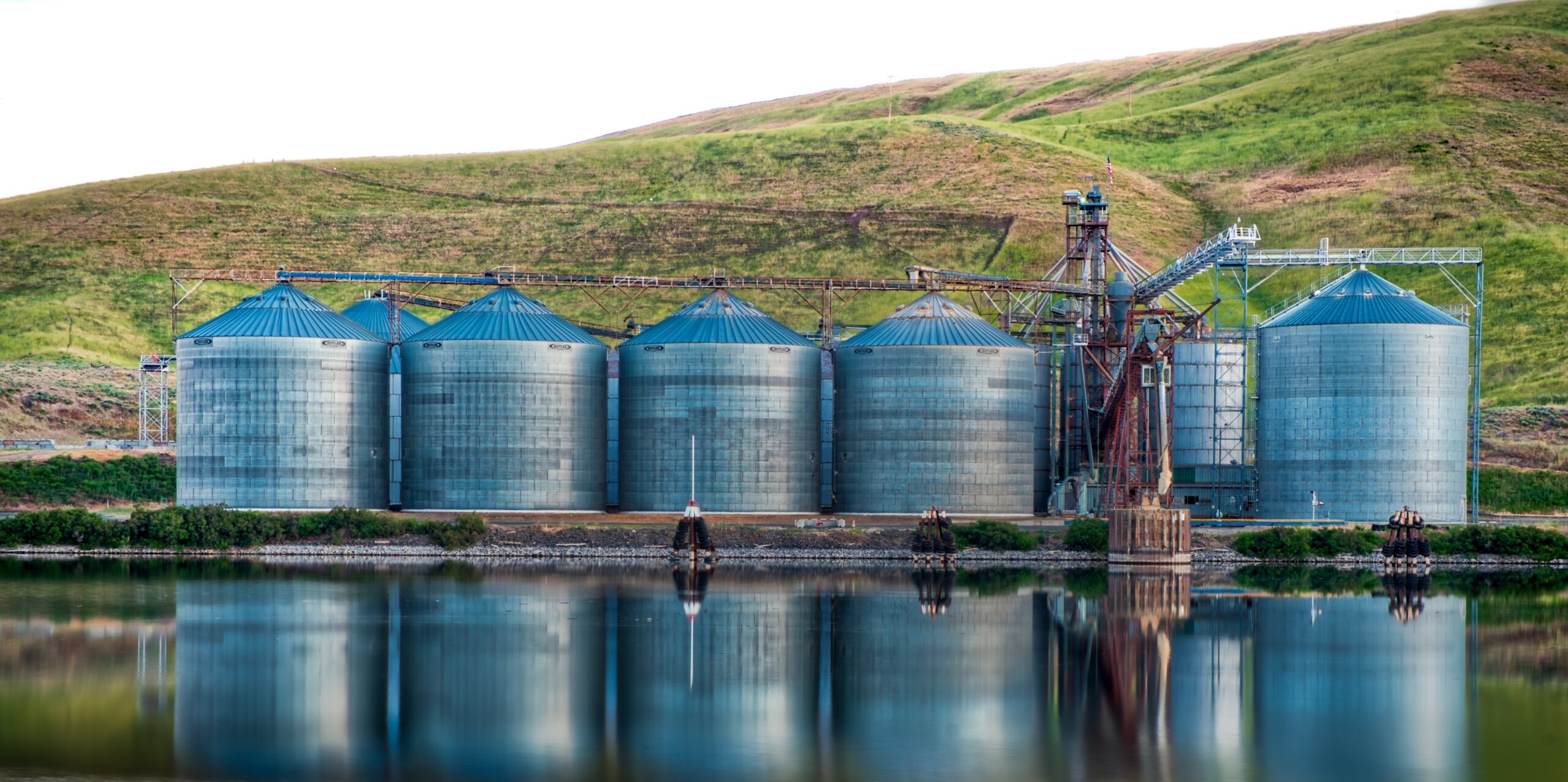 Panoramic shot of industrial buildings on the shore of the lake reflected in the water
